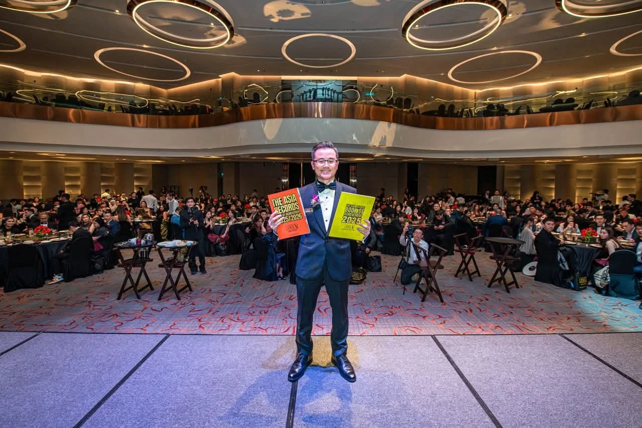 Dato' KK Chua holding Asia Record books at an official event